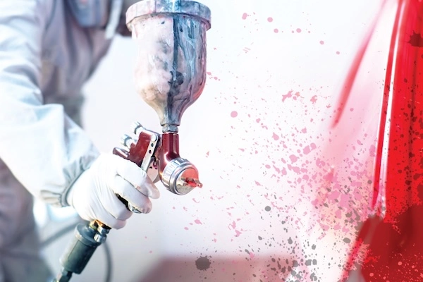 Automotive Painter Spraying a Car Red.